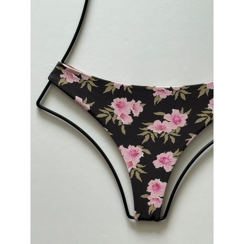 Close-up flat lay showing floral detailing and seamless cut of Acacia Swimwear bikini bottom.