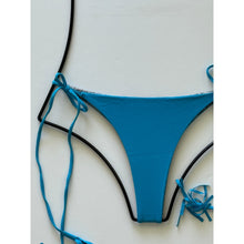 Close-up detail of ribbed blue bikini bottom fabric and leopard-print lining.
