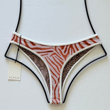 Back view of Flynn bottom with piped trim and animal print design.