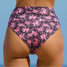 Model wearing Acacia Echo bikini bottom in Madonna print – high waist, cheeky cut with tropical floral print.