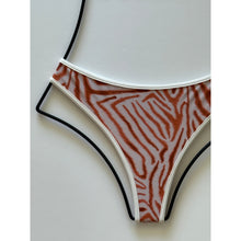 Close-up of bikini bottom showing detailed rust and cream animal print pattern.