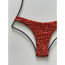 Close-up of Neon Mares pattern showing textured zebra-like design in vibrant coral red tones.