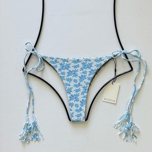 Light blue floral print Acacia Swimwear Lauie bikini bottom in Petite Rose with tassel side ties, displayed flat with brand tag.