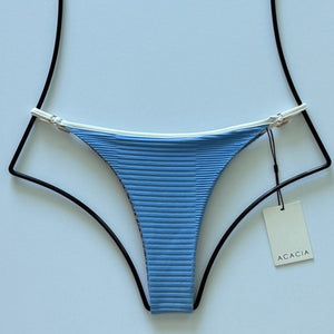 Flat lay of Acacia Swimwear Neema Piped Dual Ribbed Bikini Bottom in Seine blue with white trim, size large.