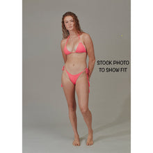 Model wearing Acacia Swimwear Lauie bikini bottom in a different color to show fit; cheeky coverage with adjustable ties.
