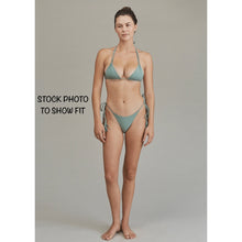 Model wearing Acacia Swimwear Lauie bikini bottom, demonstrating fit and adjustable side-tie tassels in a cheeky cut.
