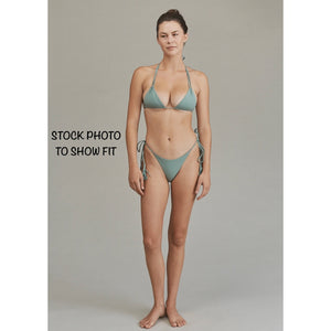 Model wearing Acacia Swimwear Lauie bikini bottom, demonstrating fit and adjustable side-tie tassels in a cheeky cut.