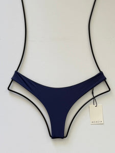 Front view of ACACIA Swimwear Ho‘okipa Bikini Bottom in Cobalt blue, low-rise cheeky Brazilian cut, skimpy coverage, flat lay with ACACIA tag.