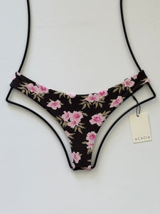 Acacia Swimwear Ho’okipa bikini bottom in Floret print, front view. Dark brown base with pink floral design, cheeky Brazilian cut, minimal coverage.
