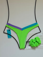 Back view of OneOne Swimwear Jesse Bikini Bottom in Nissi Neon Green with aqua and lilac V-shaped waistband, cheeky cut design, size medium, flat lay with matching scrunchie.
