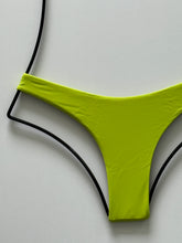 Close-up of Acacia Swimwear Wasabi bikini bottom highlighting smooth fabric and bold neon-lime tone.