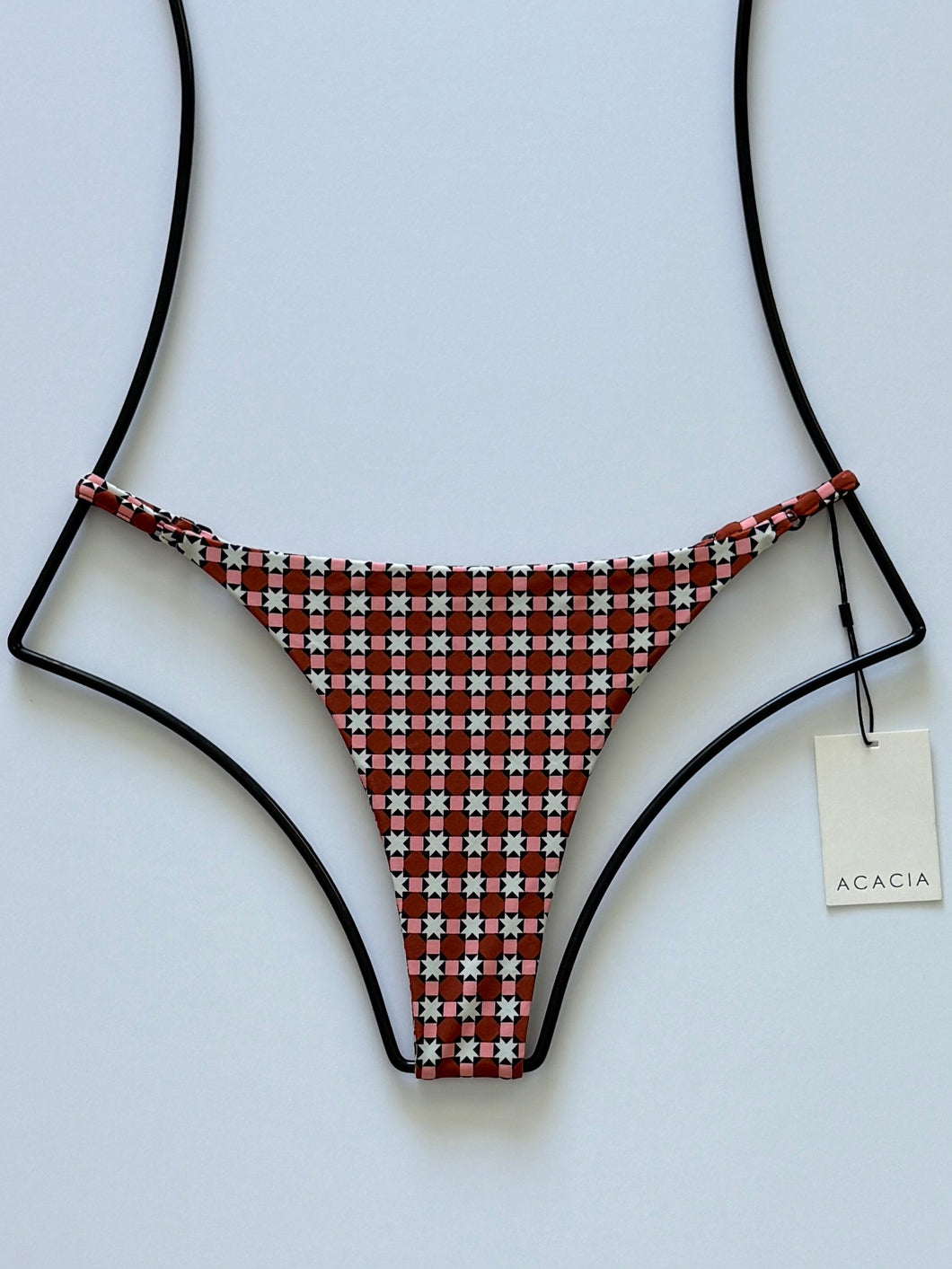 Front flat lay of Acacia Swimwear Ralphy Bikini Bottom in Sidi, terracotta and cream geometric print with adjustable straps.