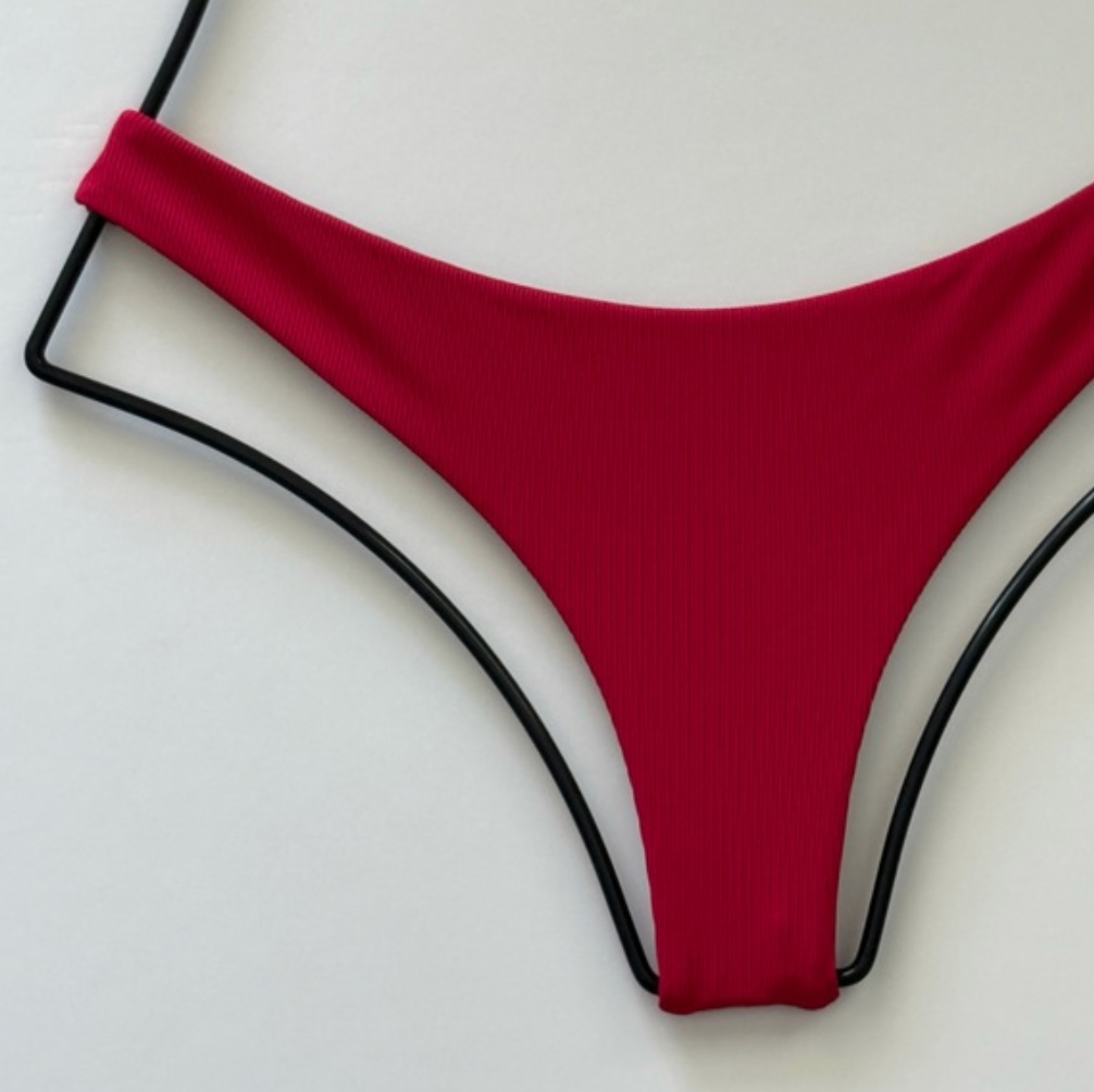 Close-up of Acacia Ho’okipa ribbed bikini bottom in Sangria red, highlighting ribbed texture and seamless design.