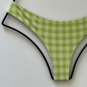 Close-up of Acacia Ho’okipa Bikini Bottom in Stevie green gingham print, showing recycled nylon fabric and minimal cheeky cut details.
