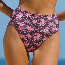 Model wearing Acacia Echo bikini bottom in Madonna print – high waist, cheeky cut with tropical floral print.