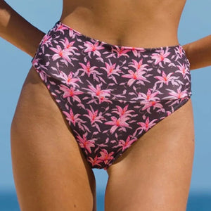 Model wearing Acacia Echo bikini bottom in Madonna print – high waist, cheeky cut with tropical floral print.