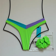 OneOne Swimwear Jesse Bikini Bottom in Nissi Neon Green with aqua and lilac V-shaped waistband, size medium, flat lay with matching scrunchie on white background