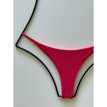 Close-up of vibrant pink mesh bikini fabric highlighting texture and detail.