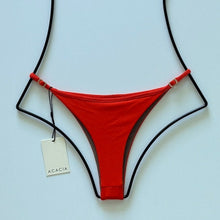 Back view flat lay of Acacia Neema Bikini Bottom with ribbed orange fabric and cheeky cut.