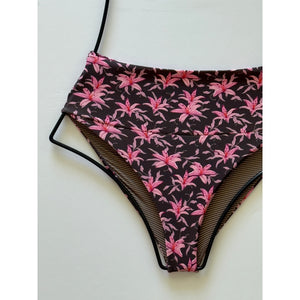 Close-up of Madonna floral print – pink lilies and green foliage on a deep brown background.