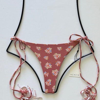 Flat lay of Acacia Swimwear Lauie bikini bottom in Dulce, dusty rose with floral print and tie sides.