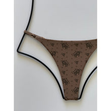 Close-up of floral print fabric and matte side strap hardware on Acacia Ralphy bottom in Aimi.