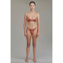 Model wearing Acacia Oslo Lining Bikini Bottom in Neon Mares showing high-cut leg and sleek fit.