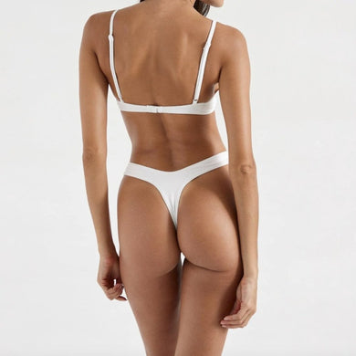 Model wearing OneOne Swimwear Heidi Skimpy Bottom in white, showing minimal coverage back view